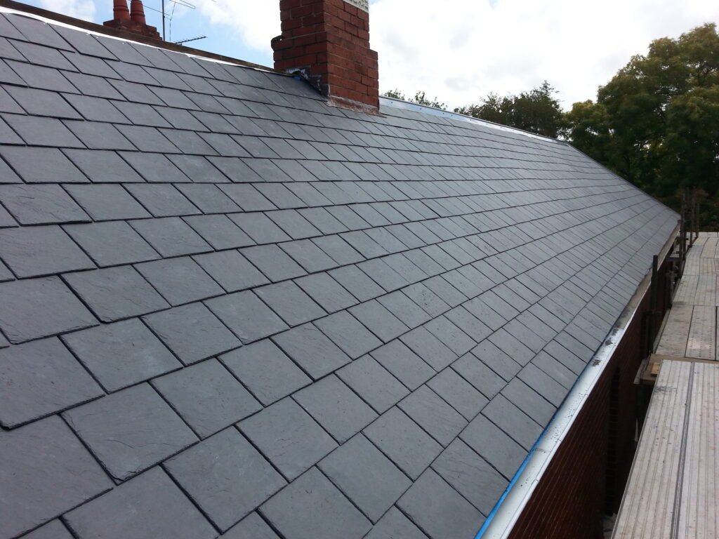 Slate roof showing careful courses around a brick chimney